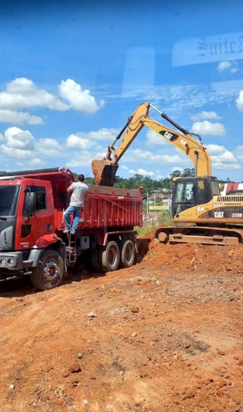 Escavadeira CAT carregando caminhão basculante em obra